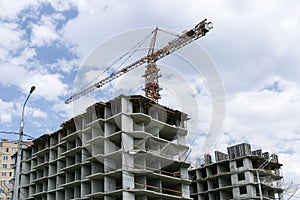 Concrete frameworks of buildings and a construction crane above them.