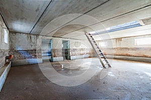 Concrete interior of unfinished garage basement apartment building trash colour with ladder and dlue day window light