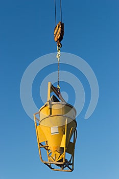 Concrete machine for spreading cement hoisted at building site on blue sky background