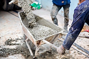 Concrete mixed cement pouring from mortar grinder truck to trolley holding by worker
