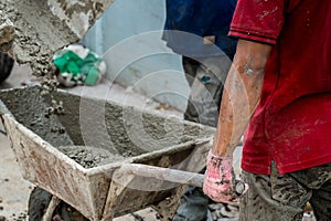 Concrete mixed cement pouring from mortar grinder truck to trolley holding by worker