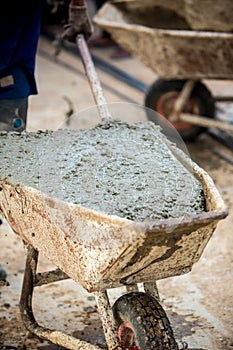 Concrete mixed cement pouring from mortar grinder truck to trolley holding by worker