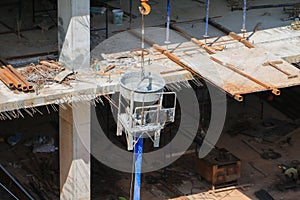 Concrete mixer and crane hook lifting container in construction site