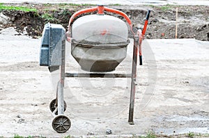 Concrete mixer is left after working time at construction site on the street.