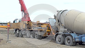 Concrete mixer truck delivers unloads loads mortar to mobile pump. Construction machinery works on site or building