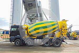 Concrete mixer truck in front of a concrete batching plant, cement factory