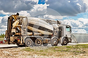 Concrete mixer truck in front of a concrete batching plant, cement factory. Loading concrete mixer truck. Close-up. Delivery of