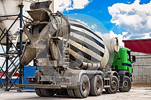 Concrete mixer truck in front of a concrete batching plant, cement factory. Loading concrete mixer truck. Close-up. Delivery of