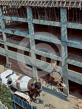 Concrete mixer truck pouring liquid concrete into the tower crane bucket at the construction site sanpada Navi Mumbai Maharashtra