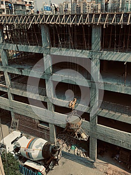 Concrete mixer truck pouring liquid concrete into the tower crane bucket at the construction site sanpada Navi Mumbai Maharashtra