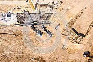 Concrete mixer trucks filling cement into house foundation framing. aerial view