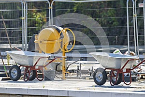 A concrete mixer and wheelbarrows