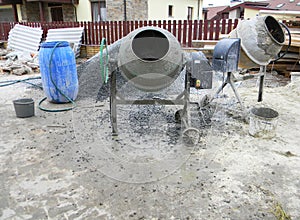 Concrete mixers with pouring cement on house construction site