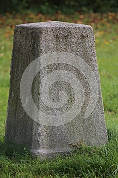 Concrete obelisk standing on a green lawn