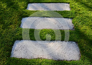 Concrete path lawn pedal rectangular shape in regular grid routed directly through beautiful lawn suns and shadows stone photo