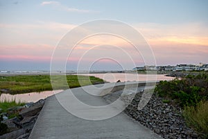 A Concrete Path With an Orange and Blue Sunset Sky Behind It at the North Wildwood Sea Wall in New Jersey