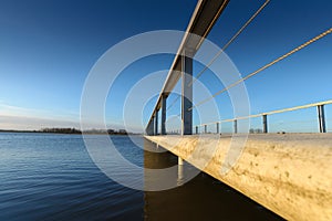 Concrete pedestrian bridge with metal railing in perspective.