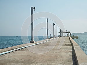 Concrete pier on sea/ocean with blue sky background