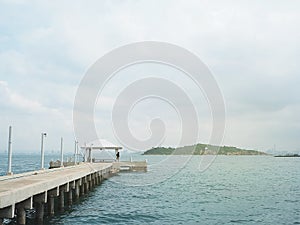 Concrete pier on sea/ocean with blue sky background