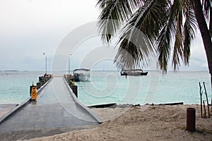 Concrete pier at white sand beach