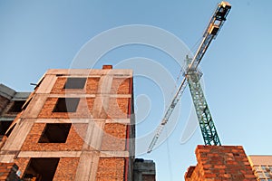 Concrete pillars on industrial construction site. Building of skyscraper with crane, tools and reinforced steel bars