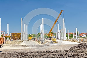 Concrete pillars of new edifice on sandy ground