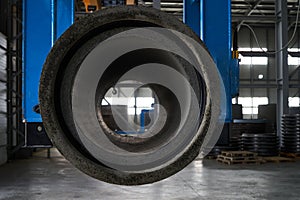 Concrete pipe on crane in factory warehouse