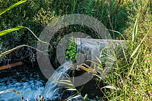 Concrete pipe transporting the poluted river photo