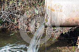 Concrete pipe transporting the poluted river photo