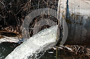 Concrete pipe transporting the poluted river photo