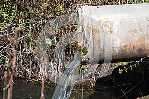 Concrete pipe transporting the poluted river photo