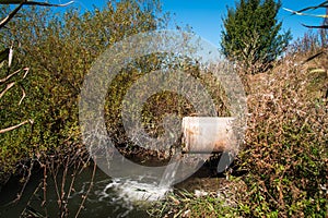 Concrete pipe transporting the poluted river photo