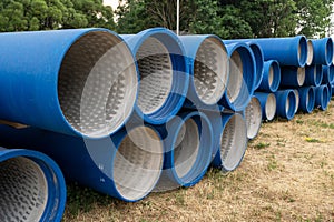 Concrete pipes covered with blue waterproofing at construction site