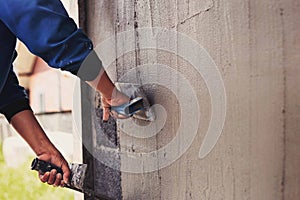 Concrete plasterers to create industrial workers background walls with plastering tools