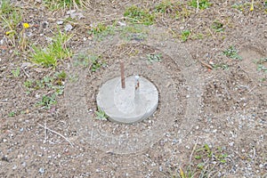 Concrete post with rebar for building a house is driven into the ground