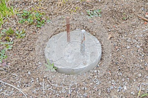 Concrete post with rebar for building a house is driven into the ground