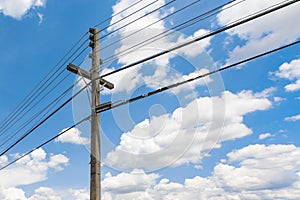 Concrete power pole and electrical wires in thailand with beautiful cloudy blue sky at afternoon sunlight and shadow