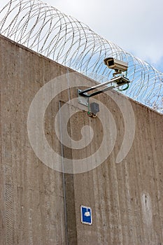 Concrete prison wall with surveillance camera