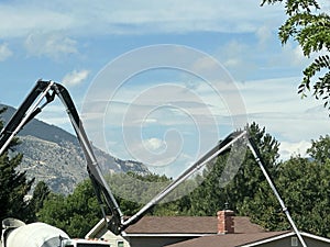 Concrete pumper moves cement across ground & buildings from the big truck.