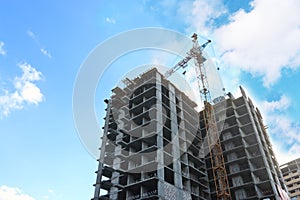 Concrete residential building under construction and crane