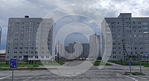 Concrete residential buildings have recently been built in the new city quarter. New roads, lighting poles. Near the houses there