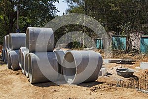 Concrete ring wells with different diameters and gray lie in the street