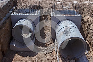 Concrete ring wells with different diameters and gray lie in the street