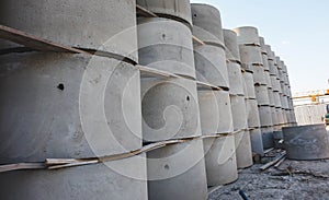 Concrete ring wells with different diameters and gray lie in the street