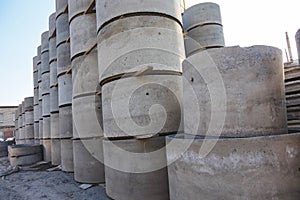 Concrete ring wells with different diameters and gray lie in the street