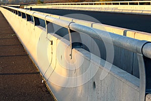 Concrete road bridge barrier with metal guard rails