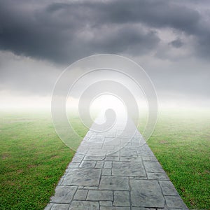 Concrete road in Grass fields and rainclouds