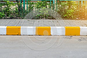 Concrete sidewalk with yellow and white curb