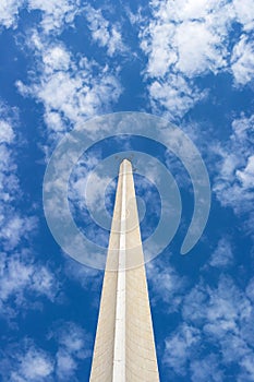 The concrete spire of the antenna rises up against the blue sky