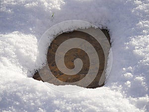 Concrete spot on the ground surrounded by freshly fallen snow